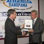 Yiorgos Kalofolias, chief executive officer of Kalofolia Express Group hands the honorary award to the Cyclades Prefect Dimitris Bailas.