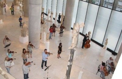The Orchestra of Colors playing orchestral pieces from “Gioconda's Smile” (Manos Hadjidakis) - view from the terrace overlooking the New Acropolis Museum’s hall of ancient sculptures.