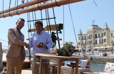 Kivotos manager Jason Michopoulos and Poseidonion Grand Hotel CEO Antonis Vordonis on the 25-meter schooner, the Prince de Neufchatel, moored in front of the Poseidonion Grand Hotel.