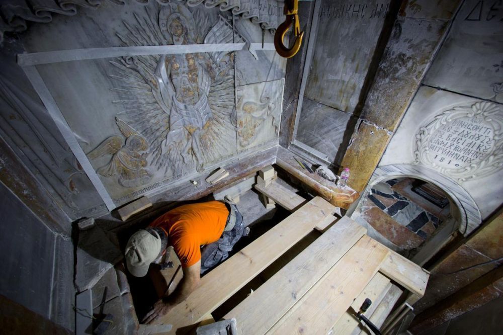 A conservator cleans the surface of the stone slab venerated as the final resting place of Jesus Christ. Photo source: National Geographic, Photograph by Oded Balilty, AP