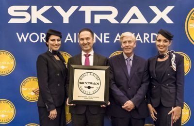 AEGEAN Chief Financial Officer Mihalis Kouveliotis, with cabin crew members, after receiving the award from Skytrax CEO Edward Plaisted. Photo source: AEGEAN