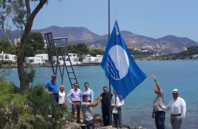 The management team of Minos Beach raises the Blue Flag.