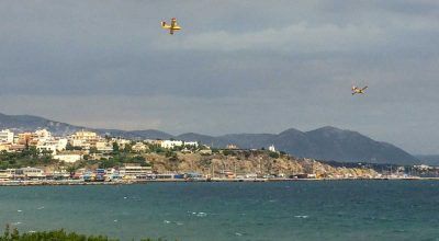 Canadair fire-fighting planes diving into the port of Rafina earlier on Tuesday, as efforts continued.