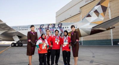 Special Olympics athletes infront of the branded Boeing 787-9 flanked by Etihad Airways cabin crew.