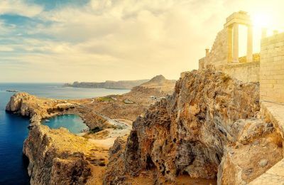 Greece. Rhodes. Acropolis of Lindos. Doric columns of the ancient Temple of Athena Lindia the IV century BC and the bay of St. Paul.