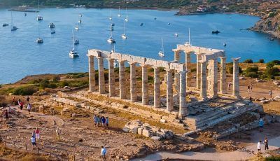 Aerial view of the beach and Temple of Poseidon at Cape Sounion at the edge of Attica, Greece, during summer sunset time. Photo source: Visit Greece