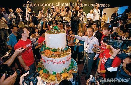 Japanese Environment Minister Ichiro Kamoshita (right) cuts a 10th anniversary birthday cake initiated by the youth group “Greenpeace-Solar Generation” at the UN Climate Change Conference in Bali.