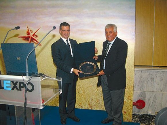 The Hellenic Hotel Federation's honorary chairman and president of the Rhodos Hoteliers Association, Vasilis Minaidis, received an honorary plaque from Tourism Minister Aris Spiliotopoulos for his valuable presence within the hotel industry. The award was given within the framework of the federation's presidents meeting during the Philoxenia exhibition.