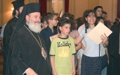 Archbishop Christodoulos congratulating a student and teacher from the Avgoulea-Linardatou School of Peristeri in Attica.