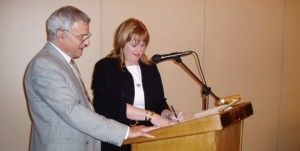 Tassos Pappas, president of the Greek chapter, with Brenda Anderson, CEO of SITE International, as she signs the founding document.