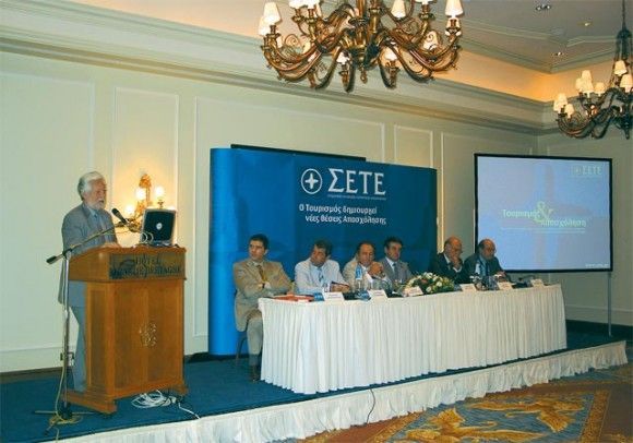 Deputy Development Minister Dimitris Georgakopoulos presents his views on tourism employment. At the panel to his left: George Dracopoulos, manager of the Association of Greek Tourism Enterprises; Leonidis Karathanasis, president of the tourism employees union; Christos Polyzogopoulos, president of the workers federation; Stavros Andreadis, president of the Association of Greek Tourism Enterprises; and association board members George Vernicos and Nikos Angelopoulos.